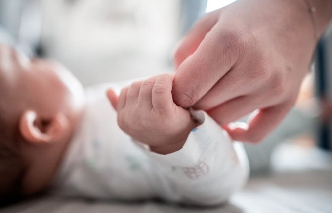 Ein Baby klammert sich an den Finger seiner Mutter: Viele Frauen möchten erst in deutlich höherem Alter als früher Kinder bekommen. Oft klappt es dann wegen altersbedingter Unfruchtbarkeit nicht mit einer Schwangerschaft.<span class='image-autor'>Fabian Strauch/dpa</span>