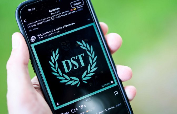 Ein junger Mann hält ein Smartphone in der Hand, auf der die Instragram-Seite von „Sturmtrupp Süd“ zu sehen ist (Symbolbild).<span class='image-autor'>Foto: Christoph Schmidt/dpa</span>