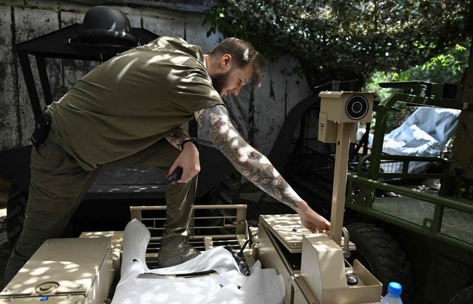 Ein ukrainischer Soldat der 93. Mechanisierten Brigade überprüft im Norden der Stadt Pokrovsk eine Bodendrohne vor ihrem Einsatz. Dieser Roboter kann Munition und Lebensmittel in die Schützengräben sowie Verwundete abtransportieren.<span class='image-autor'>Foto: AFP</span>