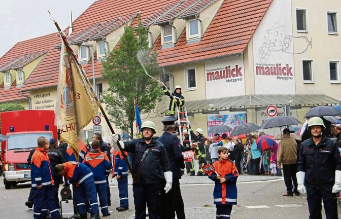 Zusätzlich zum Regen spritzen die Illinger Feuerwehrler zur Feier des Tages mit dem Schlauch.  Fotos: Rücker