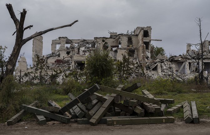 Munitionskisten liegen vor einer zerstörten Schule in einem kürzlich befreiten Dorf am Rande von Cherson.<span class='image-autor'>Foto: dpa/Bernat Armangue</span>