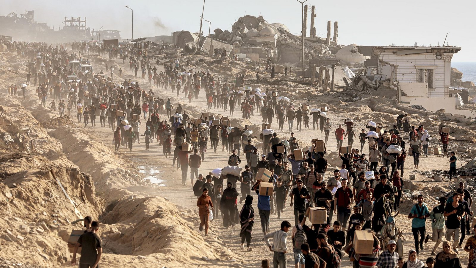 Palästinenser tragen Lebensmittel, die von der Gaza Humanitarian Foundation verteilt wurden.Foto: Omar Ashtawy/APA  via ZUMA