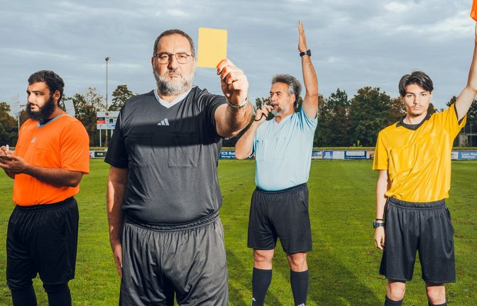 Zeichensprache auf dem  Fußballplatz:  Hasan-Fazli Kocak  zeigt die Gelbe Karte, sein Bruder Ozan  pfeift zur Halbzeit, sein Sohn Altay notiert eine Verwarnung und sein  Neffe Oguzhan signalisiert eine Abseitsstellung<span class='image-autor'>Foto: Jasper Walter Bastian</span>