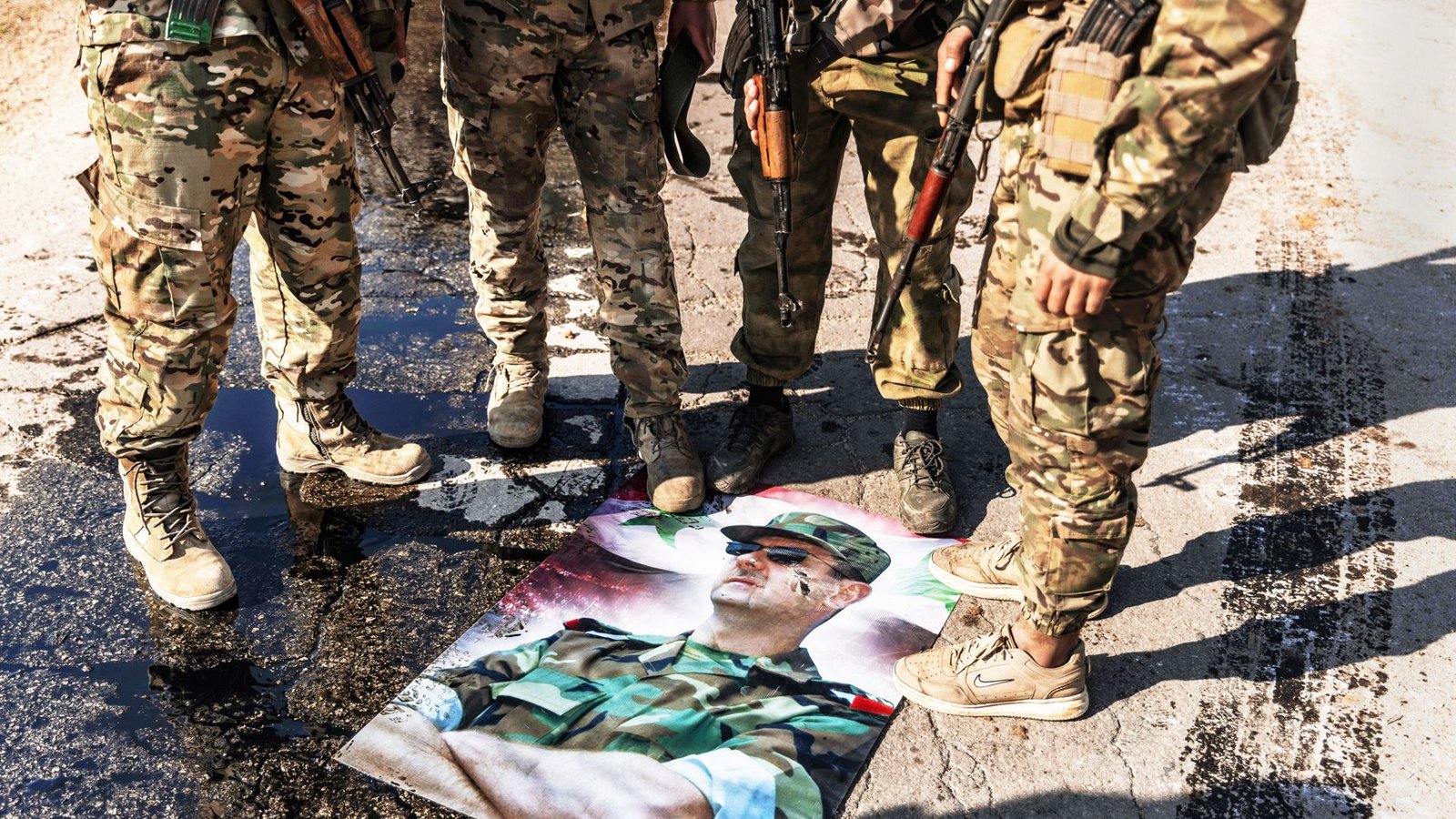 Syrische Kämpfer stehen nach ihrem Sieg auf einem Bild von Assad.Foto: dpa/Anas Alkharboutli Syrische Kämpfer stehen nach ihrem Sieg auf einem Bild von Assad.Foto: dpa/Anas Alkharboutli