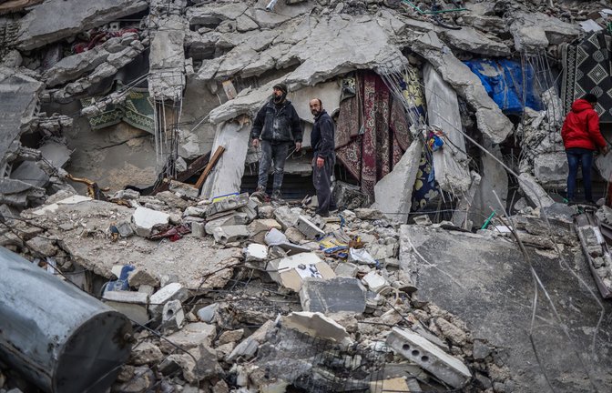 Syrische Zivilisten und Mitglieder der Weißhelme arbeiten in der syrischen Stadt Idlib an der Rettung von Menschen, die nach einem Erdbeben der Stärke 7,8 in Syrien unter einem zerstörten Gebäude eingeschlossen sind.<span class='image-autor'>Foto: Anas Alkharboutli//pa</span>