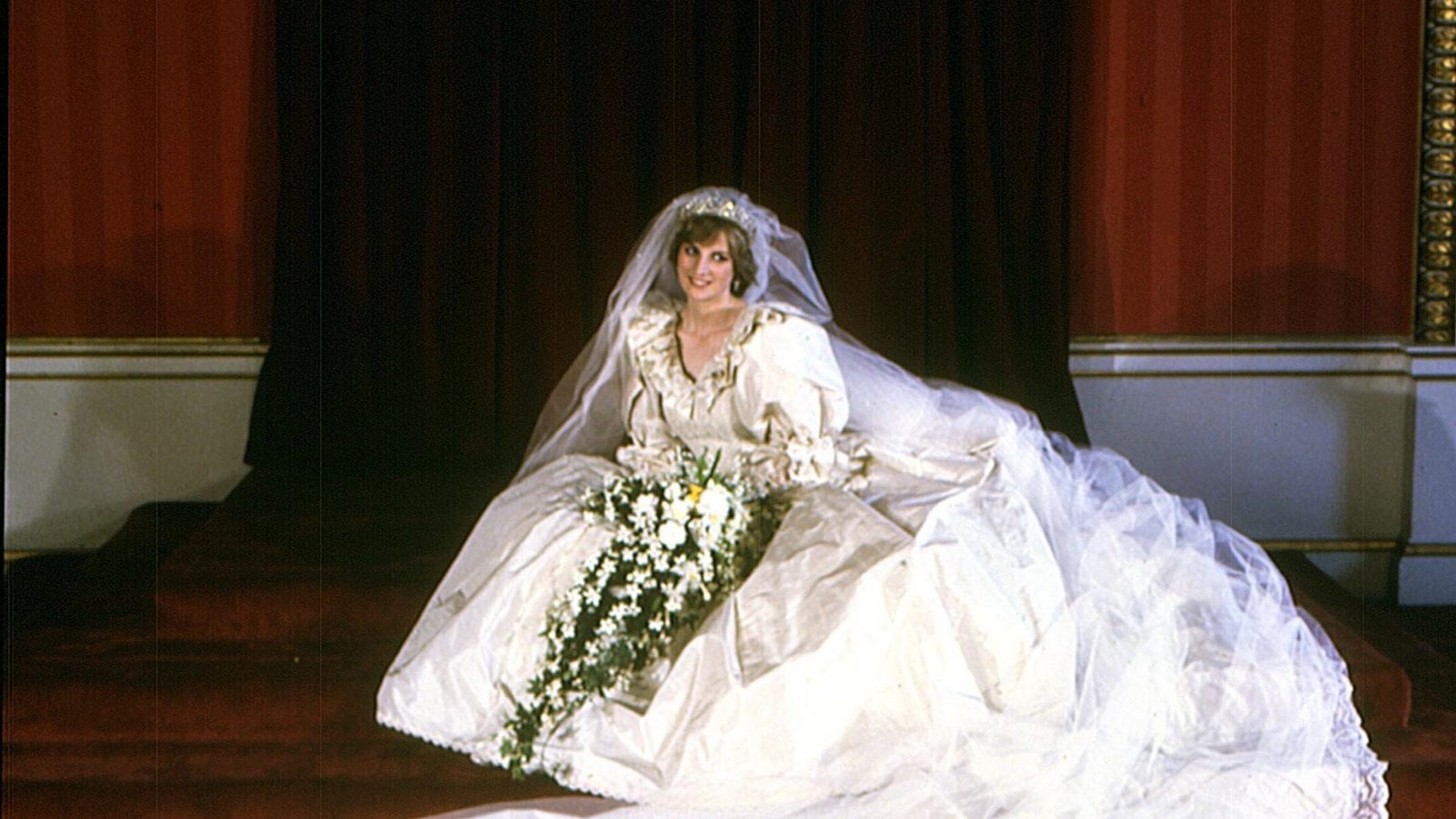 Dianas berühmtes Hochzeitskleid aus elfenbeinfarbenem Seidentaft wurde von Elizabeth und David Emanuel entworfen. Besonders auffällig waren die über 7 Meter lange Schleppe und der lange Schleier. Vor der Hochzeit war das Kleid eines der bestgehüteten Modegeheimnisse. Nach der Hochzeit prägte das Kleid mit Puffärmeln, weichen Stoffen und opulenter Silhouette einen eigenen Modetrend. Nach Dianas Tod wurde es zunächst von ihrem Bruder Charles Spencer verwahrt und später ihren Söhnen übergeben.Foto: picture-alliance / dpa | -