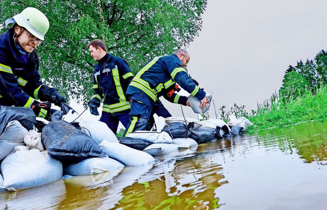 Baden-Württemberg wappnet sich gegen die Wassermassen:  Einsatzkräfte der Feuerwehr errichten wie vielerorts etwa in Bad Saulgau am Nonnenbach im Ortsteil Moosheim einen Damm mit Sandsäcken, um gegen das Hochwasser vorzugehen.<span class='image-autor'>Foto: dpa/Thomas Warnack</span>
