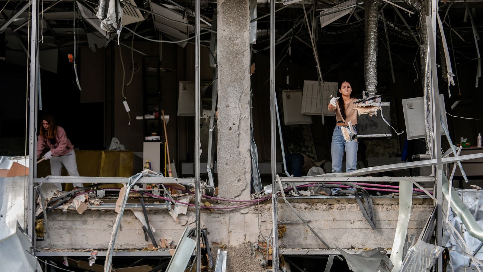 Eine Frau wirft Schutt nach draußen, während sie einen Friseursalon in Kiew aufräumt, der bei einem russischen Angriff beschädigt wurde.Foto: Julia Demaree Nikhinson/AP/dpa Eine Frau wirft Schutt nach draußen, während sie einen Friseursalon in Kiew aufräumt, der bei einem russischen Angriff beschädigt wurde.Foto: Julia Demaree Nikhinson/AP/dpa