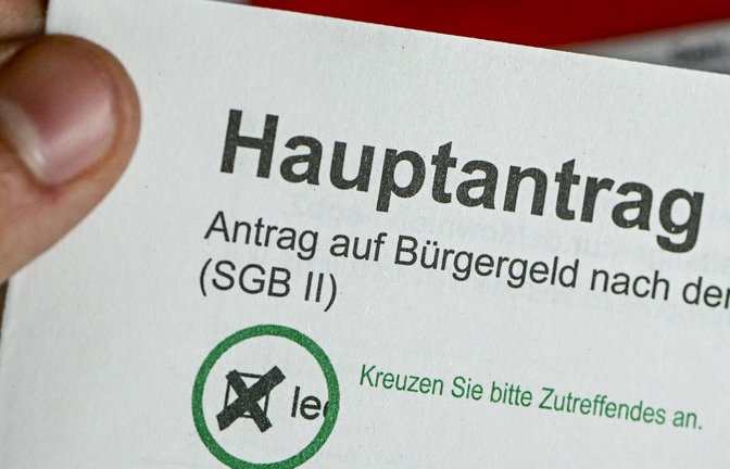 Im Jobcenter Berlin Treptow-Köpenick hält ein Mann einen Antrag auf Bürgergeld in der Hand. Das Bürgergeld wird im kommenden Jahr um rund zwölf Prozent steigen.<span class='image-autor'>Foto: dpa/Jens Kalaene</span>