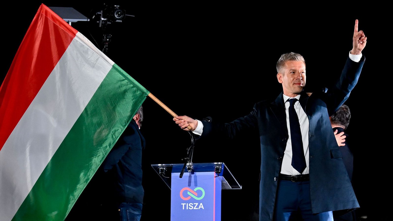 Peter Magyar, Vorsitzender der Oppositionspartei Tisza, schwenkt die ungarische Flagge nach der Bekanntgabe der Teilergebnisse der Parlamentswahl.Foto: Denes Erdos/AP/dpa