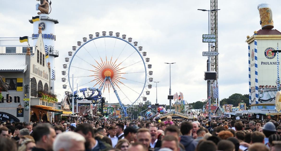 Unzählige Besucher drängen sich auf dem Oktoberfest vor dem Riesenrad.