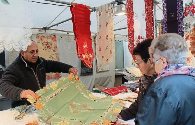 Regenwetter machte gestern dem Vaihinger Krämermarkt zu schaffen. Da galt es schnell unter die Stände zu huschen und im Trockenen weiter zu stöbern. Beim Stand von Mehmet Akin gab es unter anderem herbstliche Tischdecken.  Foto: Rostek