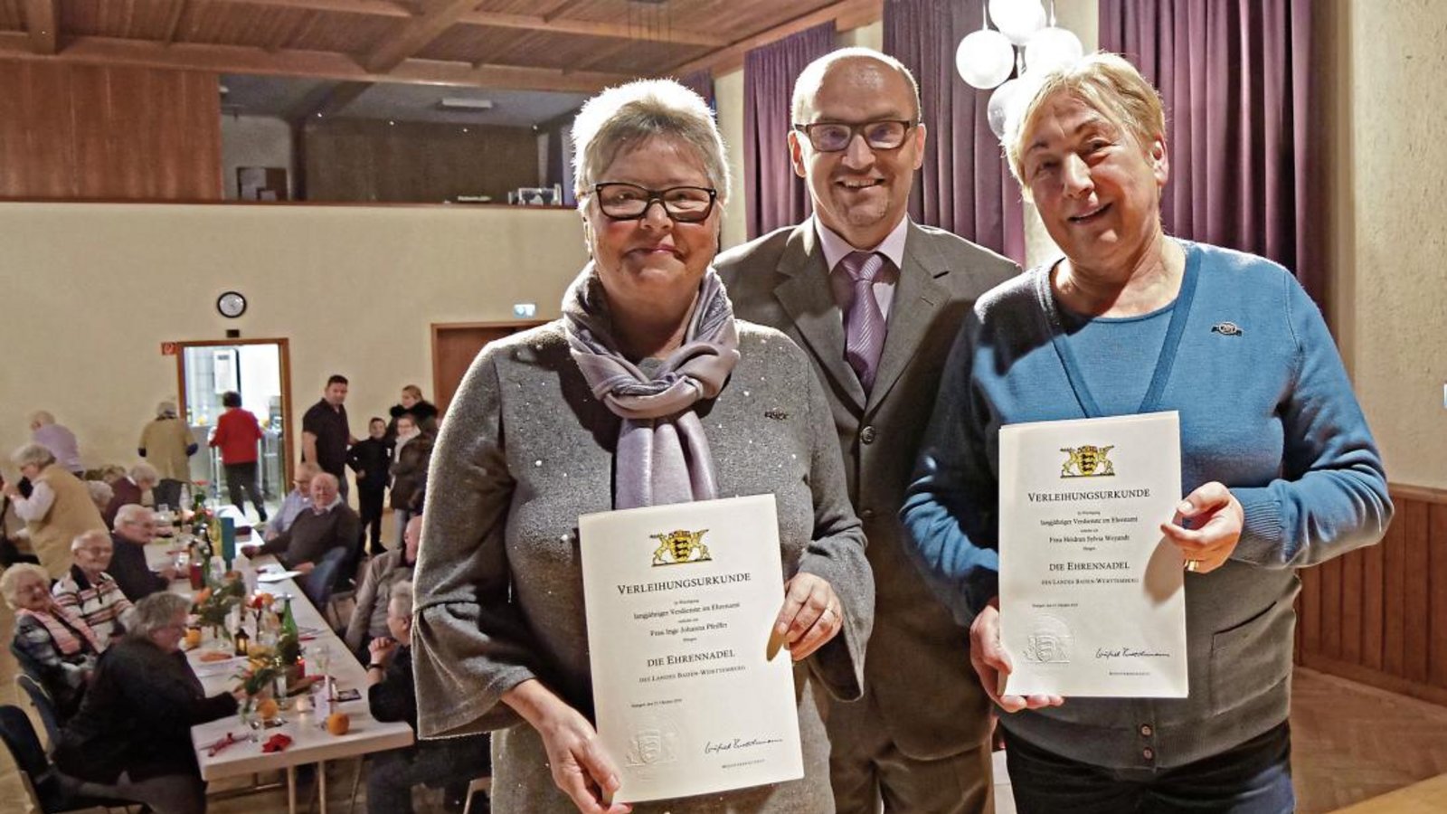 Inge Johanna Pfeiffer (links) und Heidrun Sylvia Weyandt (rechts) sind auf Initiative der Gemeinde und Bürgermeister Harald Eiberger (Mitte) beim Senioren-Weihnachtsfeier mit der Ehrennadel des Landes ausgezeichnet worden. Foto: Friedrich Inge Johanna Pfeiffer (links) und Heidrun Sylvia Weyandt (rechts) sind auf Initiative der Gemeinde und Bürgermeister Harald Eiberger (Mitte) beim Senioren-Weihnachtsfeier mit der Ehrennadel des Landes ausgezeichnet worden. Foto: Friedrich