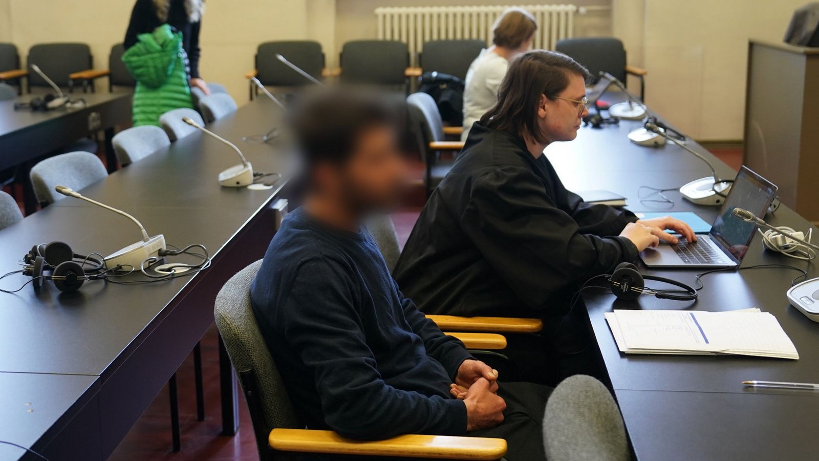 Der Angeklagte (vorne) sitzt zu Beginn des Prozesses wegen Geiselnahme seiner Tochter in Hamburg vor Gericht.Foto: dpa/Marcus Brandt