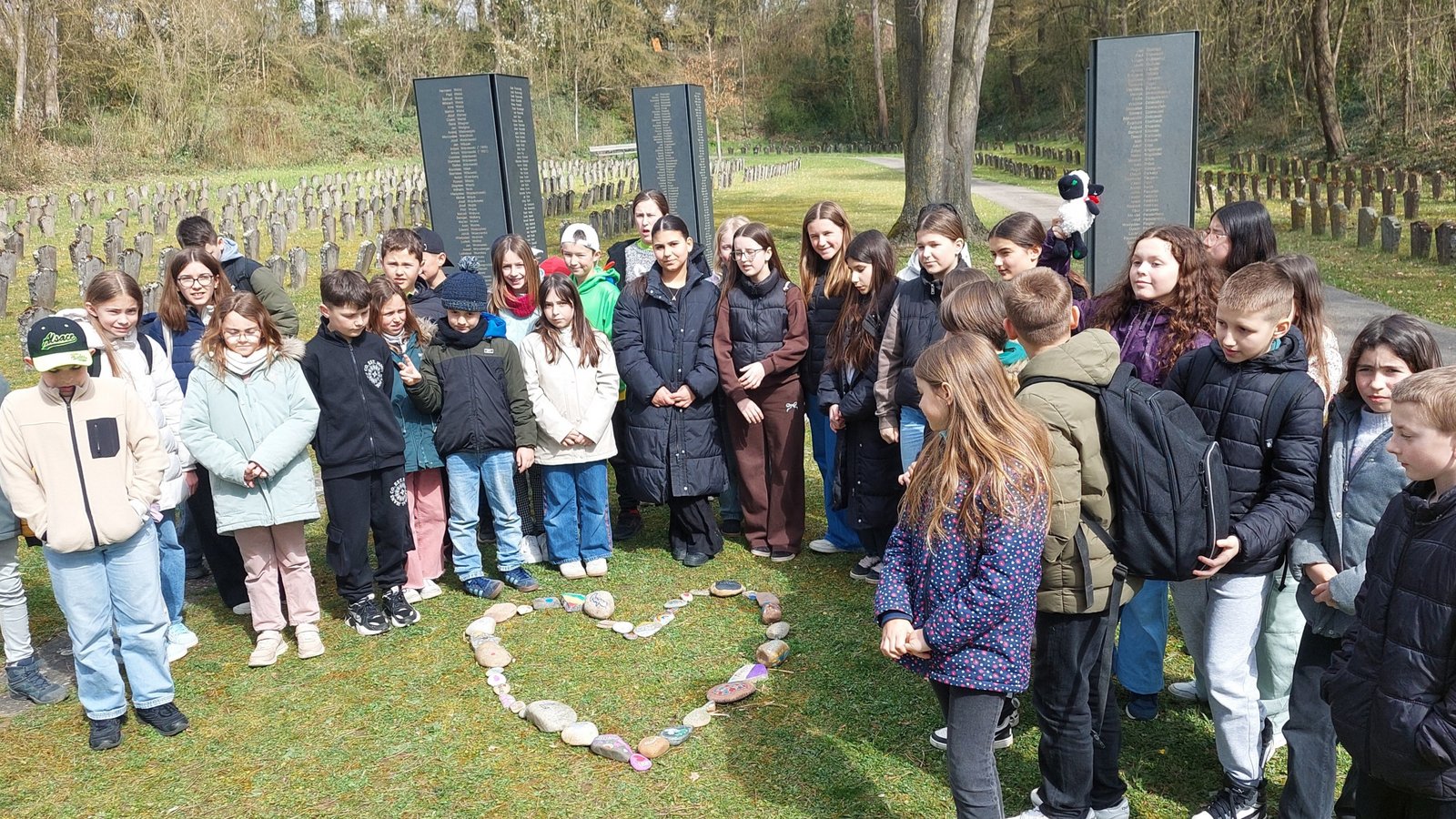 In der KZ-Gedenkstätte legen die Schülerinnen und Schüler ein Herz aus ihren selbstgebastelten Friedenssteinen. Foto: p In der KZ-Gedenkstätte legen die Schülerinnen und Schüler ein Herz aus ihren selbstgebastelten Friedenssteinen. Foto: p