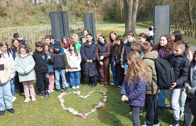 In der KZ-Gedenkstätte legen die Schülerinnen und Schüler ein Herz aus ihren selbstgebastelten Friedenssteinen. <span class='image-autor'>Foto: p</span>