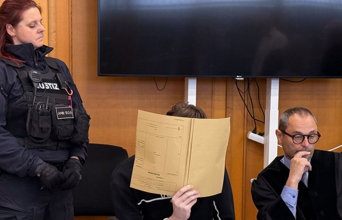 Der Angeklagte (M) verdeckt sein Gesicht vor dem Urteil im Prozess um den Tod eines zwölfjährigen Jungen auf einem Supermarktparkplatz in Niedernhall, rechts sein Anwalt Andreas Kugel (Archivfoto).<span class='image-autor'>Foto: Nico Poitner/dpa/Nico Poitner</span>