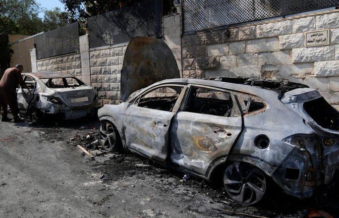 Ein Palästinenser untersucht ein abgefackeltes Fahrzeug, das nach einem Angriff israelischer Siedler zu sehen ist (Archivfoto).<span class='image-autor'>Foto: Nasser Nasser/AP/dpa</span>