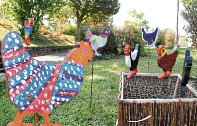 Eine freche Hühnerschar ist derzeit vor der Verwaltungsstelle und der Schule am Heulerberg in Riet zu Hause. Rektorin Birgit Körber hatte nach einer Idee zur Dorfverschönerung gesucht und da die „Heala“ der Neckname für die Rieter ist, war das Thema „Hühner“ schnell klar. Die örtliche Gruppe „Holzsterne“ sägte für jedes Kind der Klassen 3 und 4 einen Holzrohling, den diese dann gestalten konnten. Herausgekommen sind Herr Huhn, ein Zebrahuhn, ein kariertes Huhn, ein gestreiftes Huhn. Ganz zum Schluss haben zwei Jungs noch einen Stall als Unterschlupf gebaut.  Foto: Banholzer