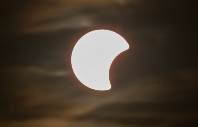 Der Beginn einer partiellen Sonnenfinsternis ist am Himmel über Dresden zu sehen. Wenn am Abend die partielle Sonnenfinsternis über Deutschland zu sehen ist, herrschen zu dieser Zeit fast überall auch optimale Wetterbedingungen, um sie zu beobachten, hieß es vom Deutschen Wetterdienst.<span class='image-autor'>Robert Michael/dpa</span>