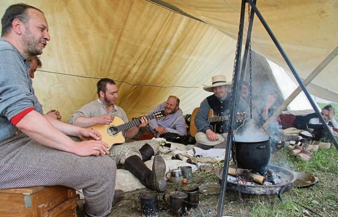 Während im Kessel Kartoffeln kochen, singen die Männer das Lied „One“ der Rockband U2.  Fotos: Thaler