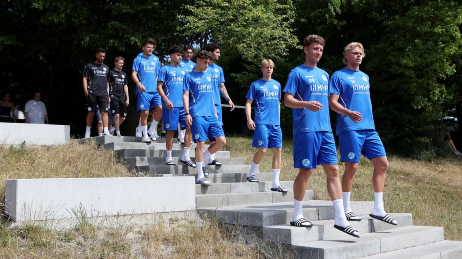 Die Neuzugänge auf dem Weg zum Trainingsplatz:&nbsp; vorne v.l.&nbsp; Malik Sama und Laurin Völlmerk; 2. Reihe, v.l. Nico Molinari und Christoph Meister; 3. Reihe v.l.  Leandro Mendes-Rangel und Ardi Mulaj; 4. Reihe v.l.  Yannick Glessing,  Ben-Luca FisherBaumann/Julia Rahn