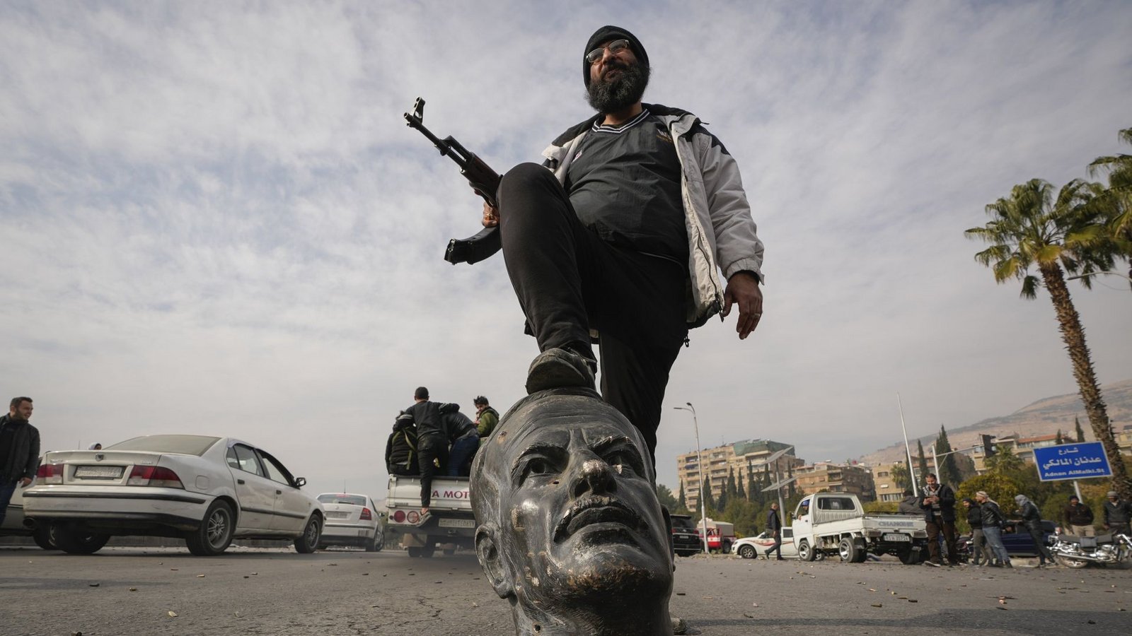 Ein Oppositionskämpfer tritt auf den abgetrennten Kopf einer Statue des verstorbenen syrischen Präsidenten Hafis al-Assad. Die neuen Machthaber in Syrien haben sich mit „allen bewaffneten Gruppen“ auf deren Auflösung geeinigt (Archivfoto).Foto: dpa/Hussein Malla Ein Oppositionskämpfer tritt auf den abgetrennten Kopf einer Statue des verstorbenen syrischen Präsidenten Hafis al-Assad. Die neuen Machthaber in Syrien haben sich mit „allen bewaffneten Gruppen“ auf deren Auflösung geeinigt (Archivfoto).Foto: dpa/Hussein Malla