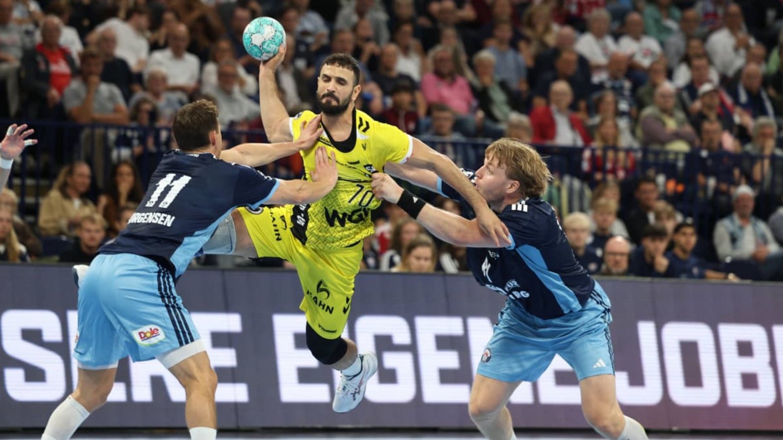 Mohamed Amine Darmoul setzt sich gegen die Hamburger Nicolaj Jörgensen (li.) und Martin Hovde durch&nbsp;– der Rückraumspieler setzte beim 34:34 im Auswärtsspiel wichtige Akzente.IMAGO/LobecaI