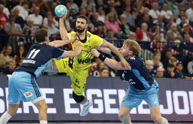 Mohamed Amine Darmoul setzt sich gegen die Hamburger Nicolaj Jörgensen (li.) und Martin Hovde durch&nbsp;– der Rückraumspieler setzte beim 34:34 im Auswärtsspiel wichtige Akzente.<span class='image-autor'>IMAGO/LobecaI</span>