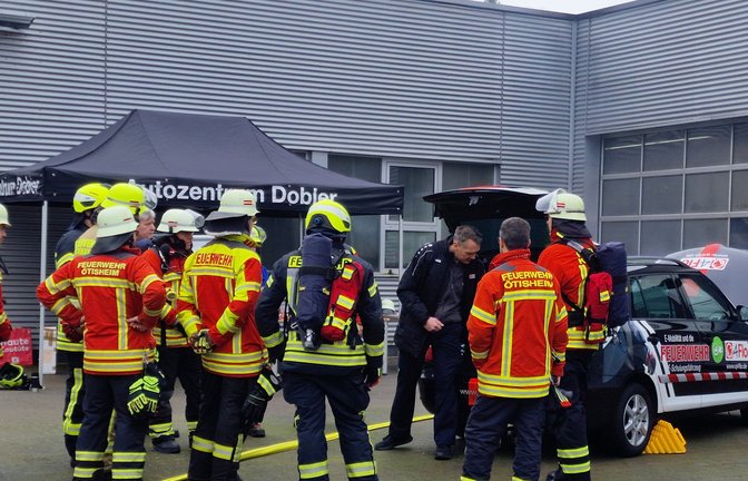 Lagebesprechung bei einem Elektrofahrzeug: Den Einsatzkräften wird erklärt, worauf sie im Brandfall besonders zu achten haben. Die Batterie etwa muss auf unter 80 Grad gekühlt werden.