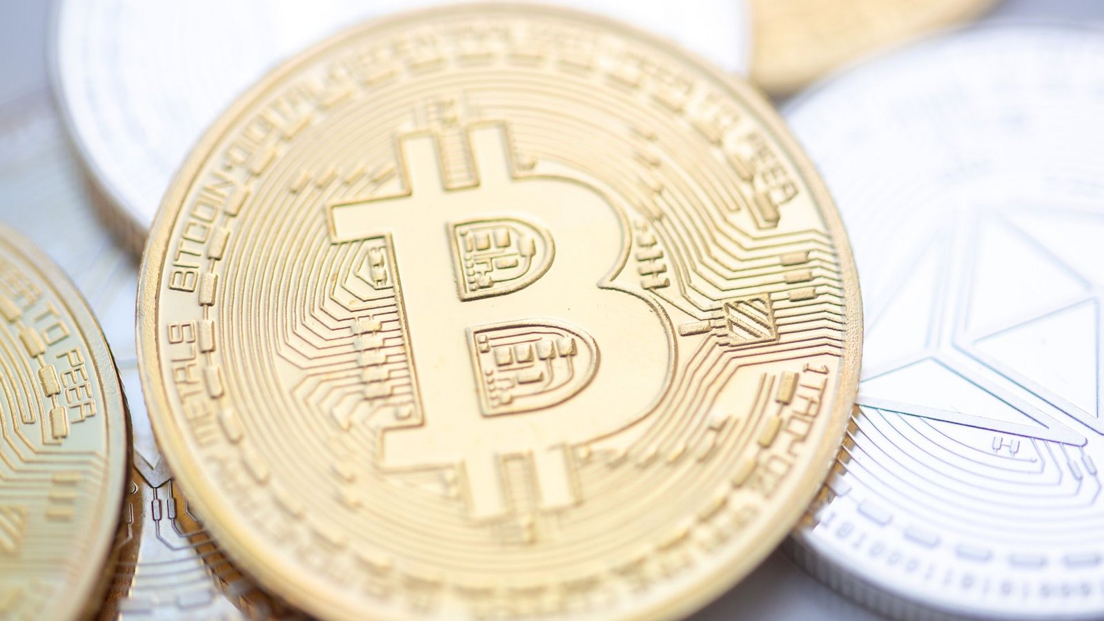 Bitcoin- (M.) und Ethereum-Münzen.Foto: Fernando Gutierrez-Juarez/dpa