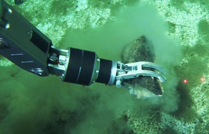 Der Roboterarm eines Tauch-U-Bootes greift nach einem Wal-Fossil: Die Forscher gehen davon aus, dass es weltweit noch viele andere solche Walfriedhöfe gibt. Allein die Fläche des Grabens schätzt es auf 14.400 Quadratkilometer. Hochgerechnet könnten in der Bruchzone mehr als zehn Millionen Walreste liegen.<span class='image-autor'>Foto: © Global TREnD/IDSSE/dpa/AP</span>