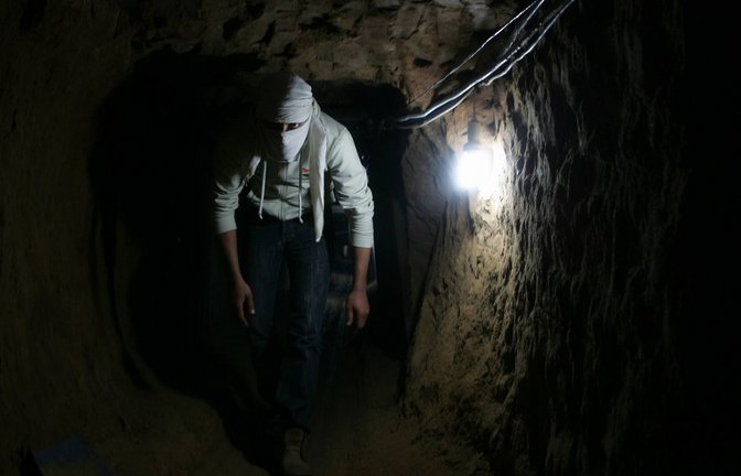 Ein Mitglied der Terrororganisation Hamas läuft gebückt durch einen Tunnel unter dem Gazastreifen.<span class='image-autor'>Foto: Imago/Stock&People</span>