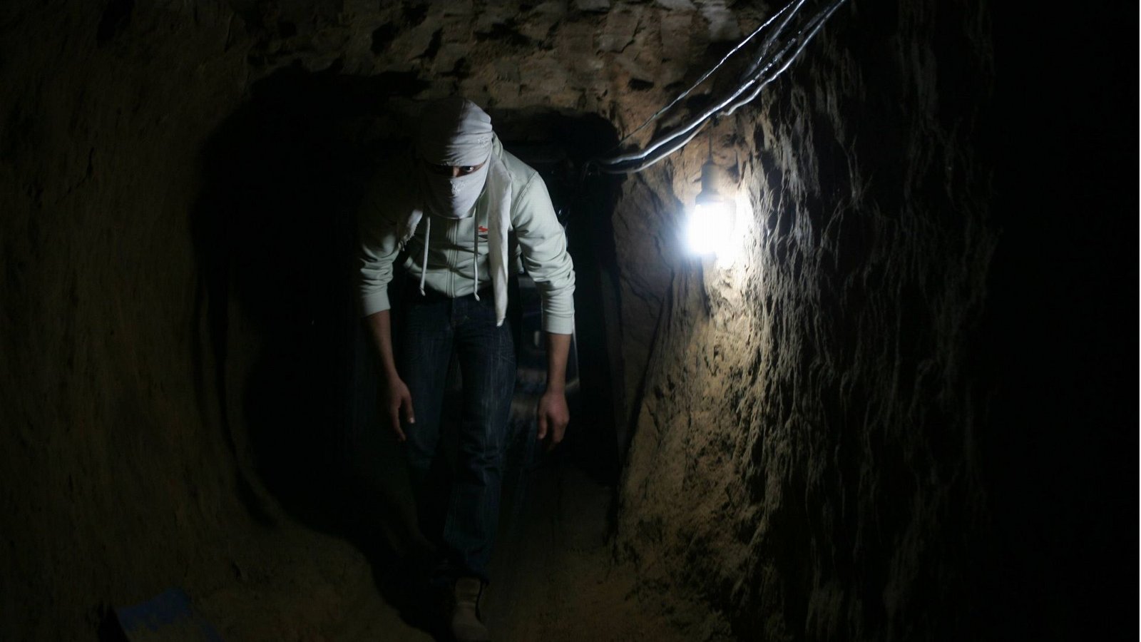Ein Mitglied der Terrororganisation Hamas läuft gebückt durch einen Tunnel unter dem Gazastreifen.Foto: Imago/Stock&People
