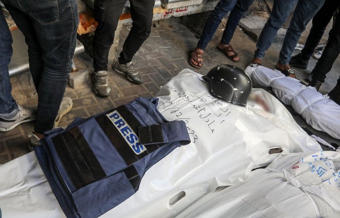 Eine Weste mit der Aufschrift «Presse» und ein Helm liegen auf dem Leichnam eines Journalisten.<span class='image-autor'>Foto: dpa/Abed Rahim Khatib</span>