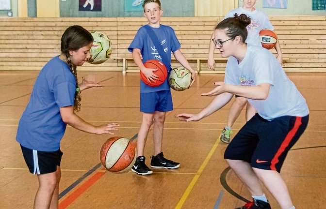Die Trainerin Anna-Catharina Polemidhiotis (rechts) erklärt der zehnjährigen Emily Schwach aus Mühlacker (links) eine Übung zum Ballhandling. Finn Arbinger und Trainerin Rebecca Roller (im Hintergrund von links) schauen zu. Foto: Simecek