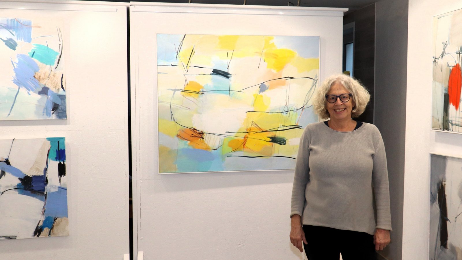 Ulrike Armbruster-Goldstein posiert vor Andreas Durrers „Frühsommerlicht“ und neben ihrem eigenen Werk „Eisblau“.  Fotos: Gergen