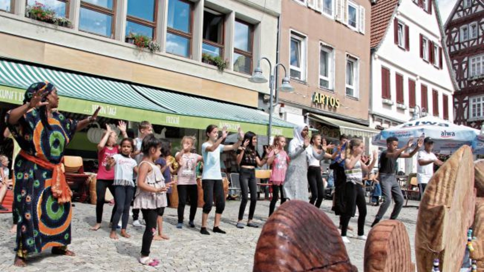 Viereinhalb Tage haben sich die Kinder beim Afrika Kunst- und Kulturcamp der Stadt Vaihingen mit dem schwarzen Kontinent befasst. Trommeln, Tanzen, Akrobatik und Maskenschnitzen standen auf dem Programm. Beim Abschluss gestern Nachmittag zeigten die Teilnehmer den begeistert mitklatschenden Zuschauern auf dem Marktplatz, was sie gelernt hatten. Foto: Banholzer Viereinhalb Tage haben sich die Kinder beim Afrika Kunst- und Kulturcamp der Stadt Vaihingen mit dem schwarzen Kontinent befasst. Trommeln, Tanzen, Akrobatik und Maskenschnitzen standen auf dem Programm. Beim Abschluss gestern Nachmittag zeigten die Teilnehmer den begeistert mitklatschenden Zuschauern auf dem Marktplatz, was sie gelernt hatten. Foto: Banholzer