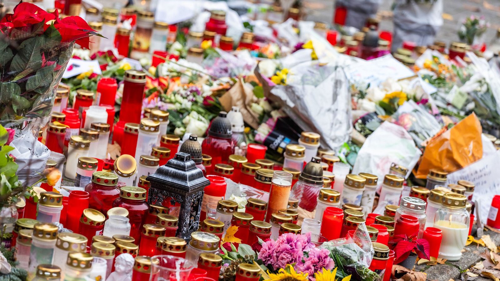 Kerzen und Blumen liegen vor dem Eingang der Waldbachschule.Foto: dpa/Philipp von Ditfurth