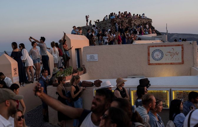 Touristen machen Selfies und genießen den Sonnenuntergang in Oia auf der Insel Santorini (Archivfoto).<span class='image-autor'>Foto: Petros Giannakouris/AP/dpa/Petros Giannakouris</span>