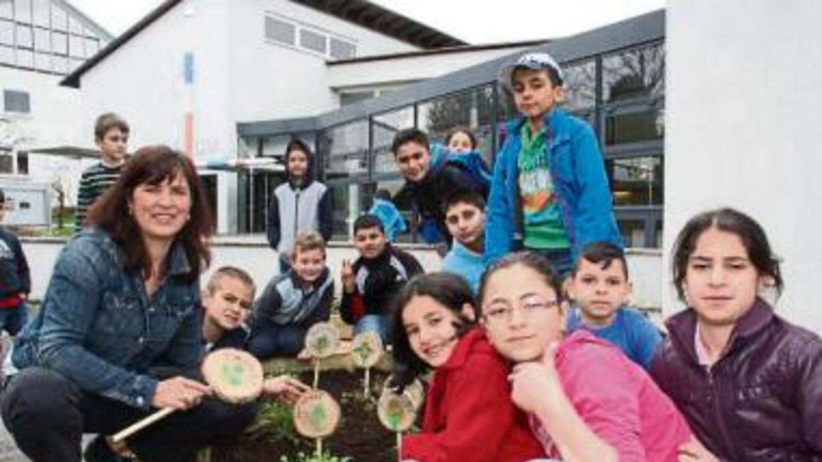 Papp steckt mit den Kindern der Vorbereitungsklasse Holzschilder in den Kräutergarten. Papp steckt mit den Kindern der Vorbereitungsklasse Holzschilder in den Kräutergarten.