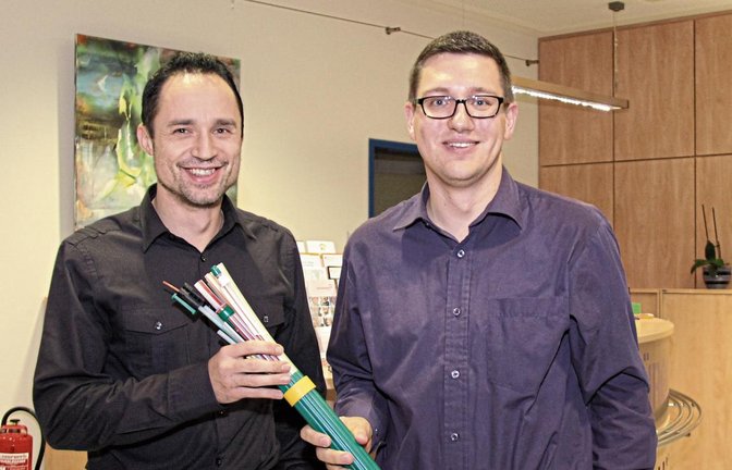 Hauptamtsleiter Sven Holz (links) und Daniel Olheide posieren mit einem der künftigen Kabel.  Foto: Romanowski