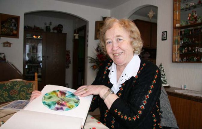 Edith Geduldig zeigt eine ihrer Wachsmalereien. Foto: Rücker