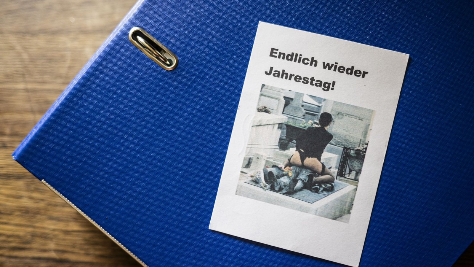 Geschmacklose Post: Zum Todestag von Susannes Ex-Mann wird dem Paar eine Karte zugeschickt, darauf zu sehen eine Frau in Unterwäsche auf einem Grab. Der Ordner mit dem belastenden Material ist prall gefüllt.Foto: Andreas Reiner