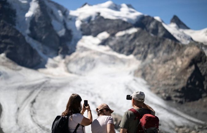 Gletscher in der Schweiz: Was auf den ersten Blick pittoresk wirkt - ein idyllischer Sommertag in den Alpen mit Touristen, die einen Gletscher fotografieren - ist in Wirklichkeit ein Warnsignal. Die Alpengletscher schmelzen immer schneller dahin.<span class='image-autor'>Gian Ehrenzeller/Keystone/dpa</span>