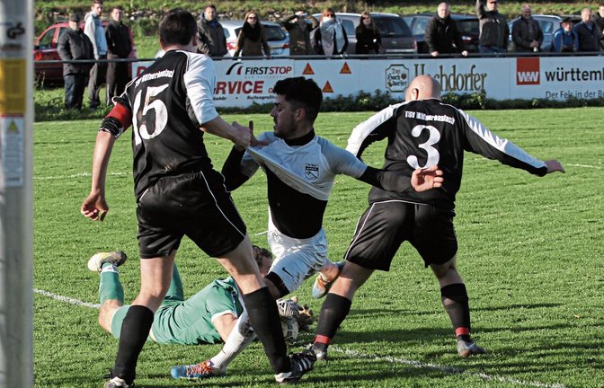 Im Nachfassen hat Marc Sladkowski (am Boden) den Ball sicher, nachdem Hakan Atalay (Mitte) den bereits am Boden liegenden Häfnerhaslacher Torwart mit einem Heber überwinden wollte. Foto: Nachreiner
