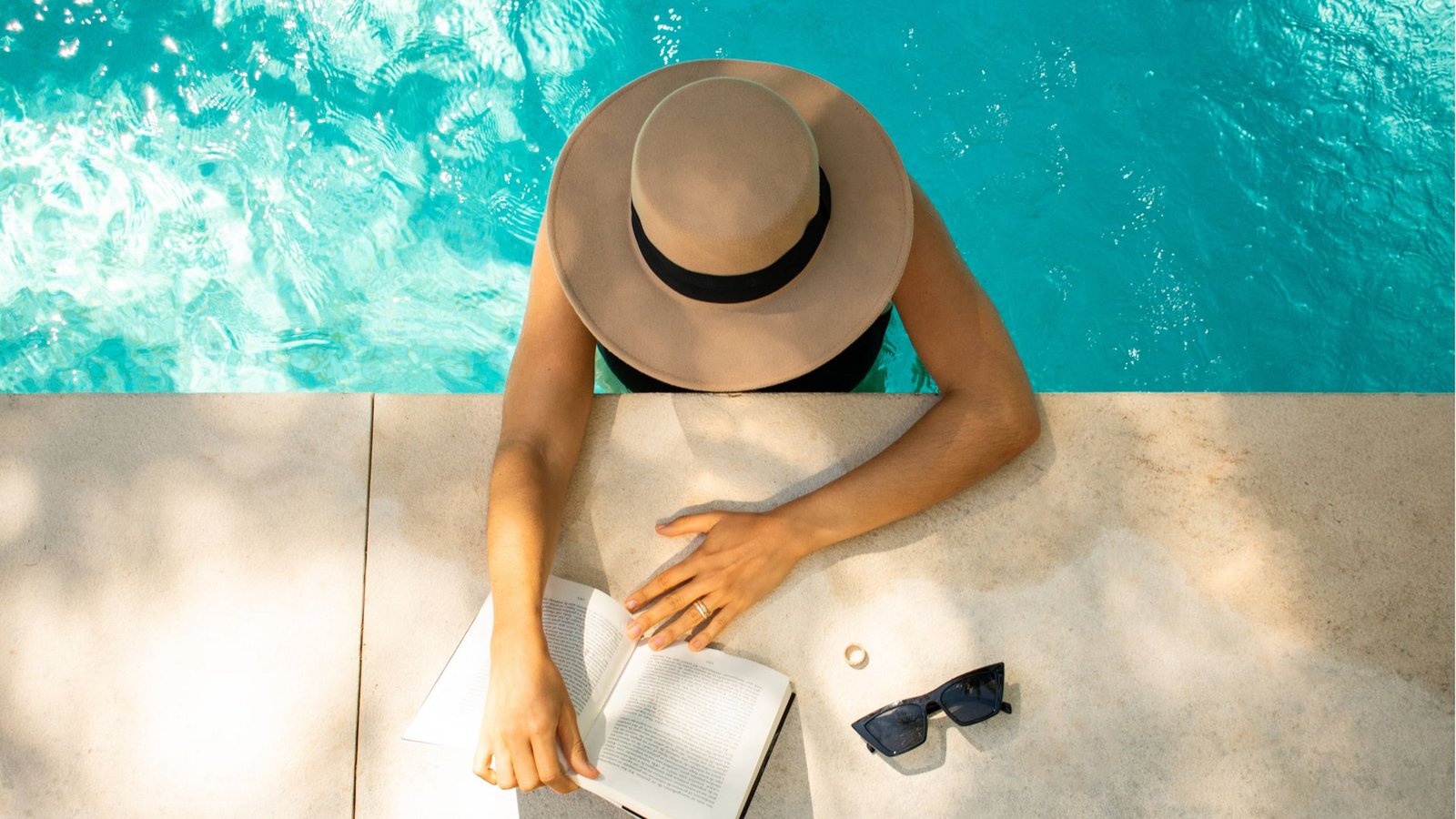 Urlaubsstimmung: Füße im Wasser, Sonne im Gesicht und ein gutes Buch in der Hand.Foto: imago images/Cavan Images Urlaubsstimmung: Füße im Wasser, Sonne im Gesicht und ein gutes Buch in der Hand.Foto: imago images/Cavan Images