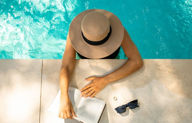 Urlaubsstimmung: Füße im Wasser, Sonne im Gesicht und ein gutes Buch in der Hand.<span class='image-autor'>Foto: imago images/Cavan Images</span>
