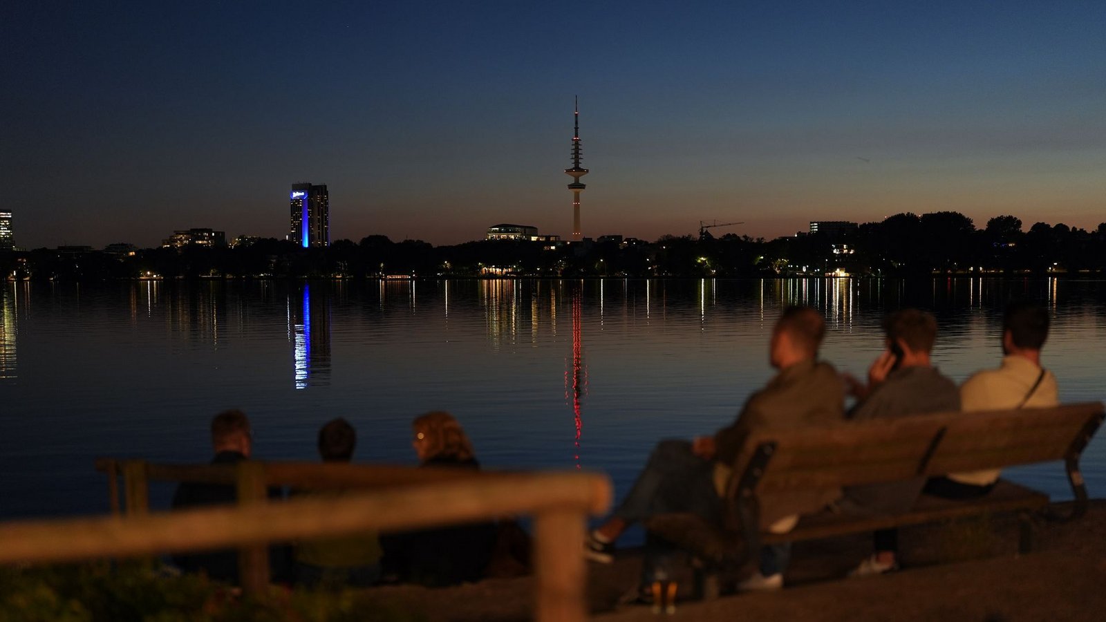 Menschen genießen die Abendstimmung am Ufer der Außenalster in Hamburg.Foto: Marcus Brandt/dpa