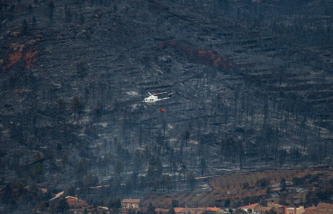 Ein Hubschrauber fliegt in San Agustin über ein verbranntes Gebiet. Vom Wald ist nicht mehr viel übrig.<span class='image-autor'>Foto: Lorena Sopêna/EUROPA PRESS/dpa</span>